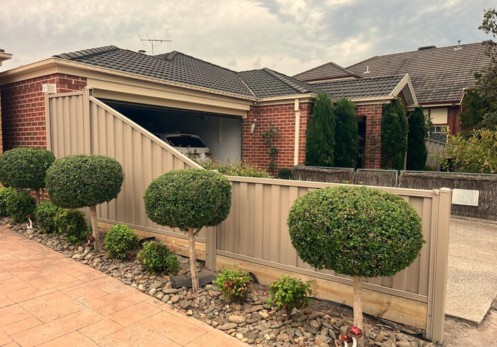sloped Colorbond fence Riversand colour installed in Keysborough